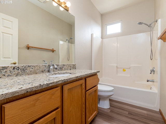 full bathroom featuring vanity, wood finished floors, toilet, baseboards, and bathtub / shower combination