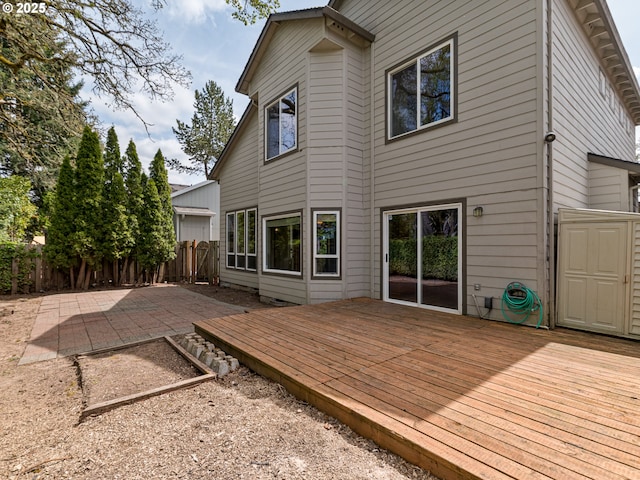 rear view of property featuring a patio, fence, and a deck