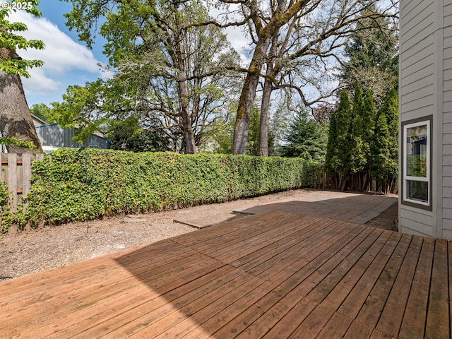 wooden deck with a fenced backyard and a patio area