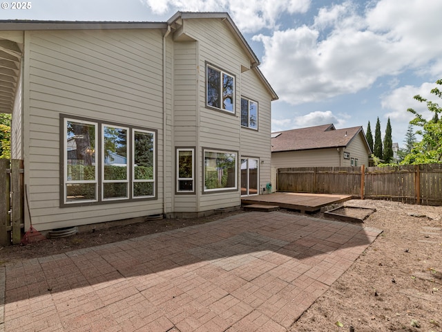 rear view of property with a fenced backyard, a patio area, and a wooden deck