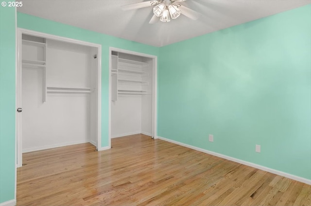 19555 SW Cascadia St, Beaverton, OR 97078 - unfurnished bedroom featuring wood finished floors, baseboards, ceiling fan, and two closets