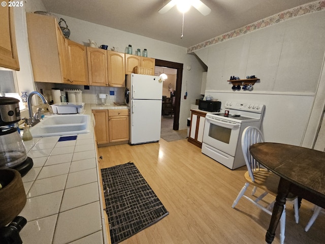 kitchen with sink, white appliances, tile countertops, light hardwood / wood-style flooring, and ceiling fan