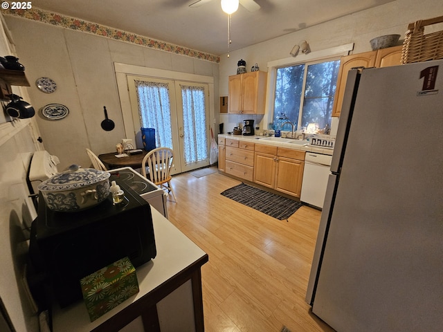 kitchen with sink, stainless steel refrigerator, dishwasher, french doors, and light brown cabinets