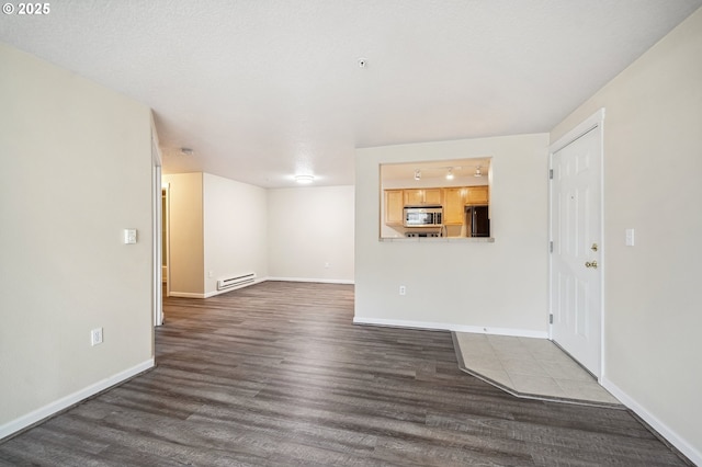 interior space with baseboard heating and dark hardwood / wood-style flooring