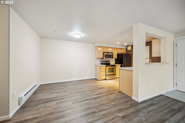 kitchen featuring a textured ceiling, light hardwood / wood-style flooring, stainless steel appliances, light brown cabinetry, and baseboard heating