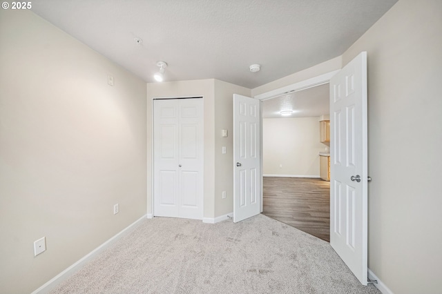 unfurnished bedroom featuring light colored carpet and a closet