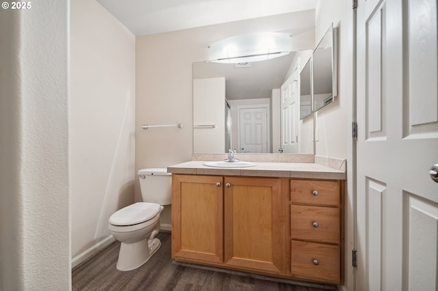 bathroom featuring toilet, hardwood / wood-style flooring, and vanity