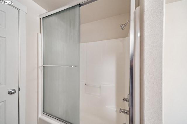 bathroom featuring bath / shower combo with glass door