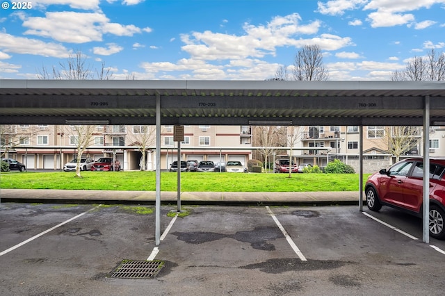 view of parking featuring a yard and a carport