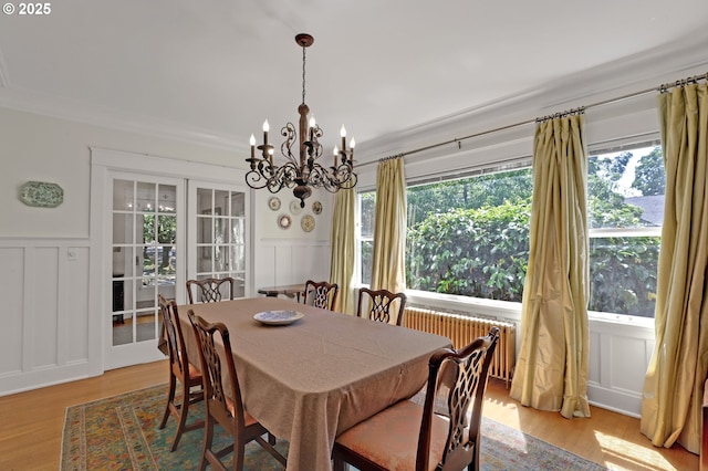 803 NE Laurelhurst Pl, Portland, OR 97232 - dining space featuring a decorative wall, radiator heating unit, a chandelier, plenty of natural light, and a wainscoted wall