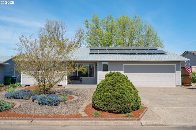 mid-century home with an attached garage, a shingled roof, concrete driveway, and solar panels