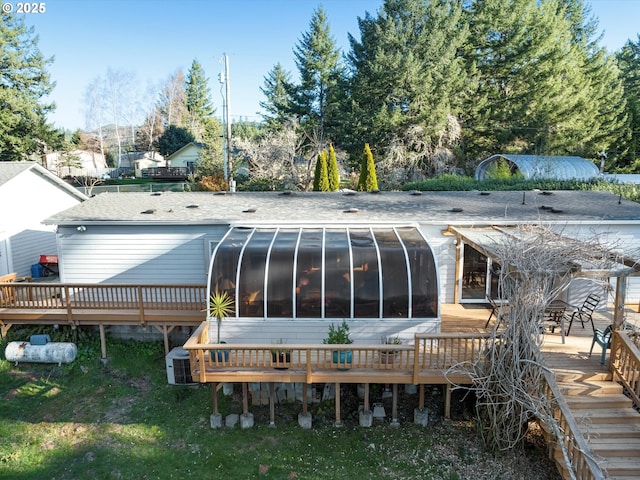 rear view of house featuring a deck and a sunroom