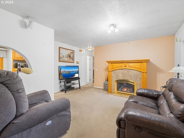 carpeted living room with a fireplace and a textured ceiling