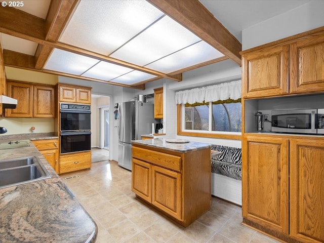 kitchen with sink, light tile patterned floors, a kitchen island, and appliances with stainless steel finishes