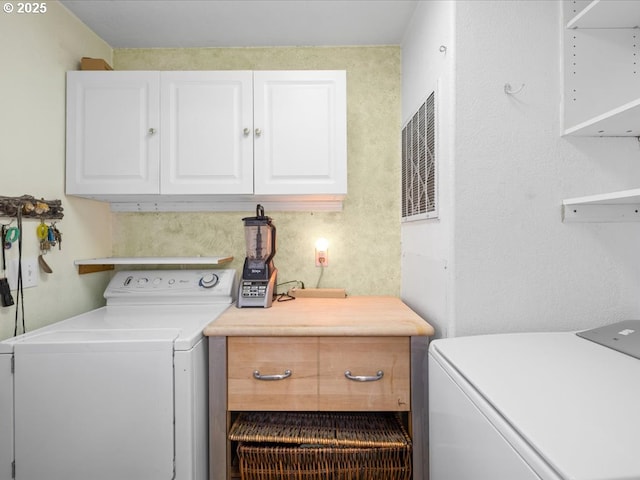 washroom with washer and clothes dryer and cabinets