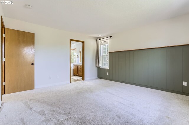 carpeted empty room with baseboards and a smoke detector