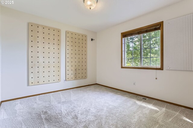 empty room featuring carpet floors and baseboards