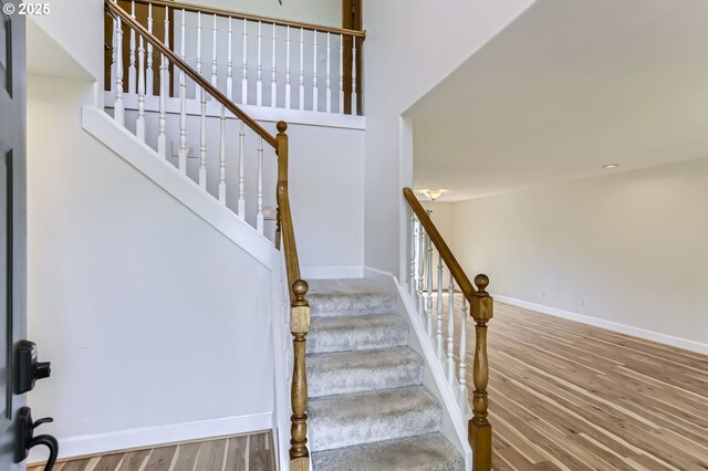 stairway featuring wood finished floors and baseboards