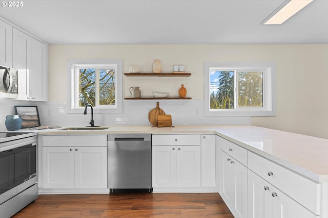 kitchen featuring plenty of natural light, sink, stainless steel appliances, and white cabinetry