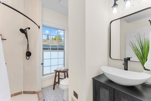 bathroom with toilet, vanity, and tile patterned floors