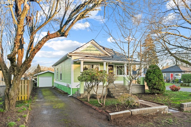 bungalow-style home featuring a garage and an outdoor structure