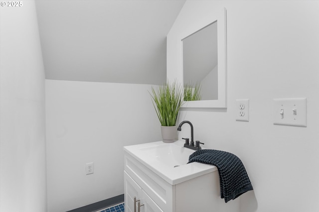 bathroom featuring vaulted ceiling and vanity