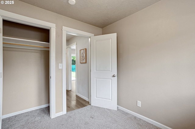 unfurnished bedroom featuring carpet flooring, baseboards, and a closet