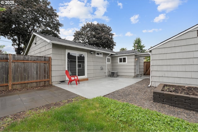 back of property with fence and a patio