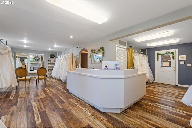 interior space with visible vents, arched walkways, and dark wood finished floors