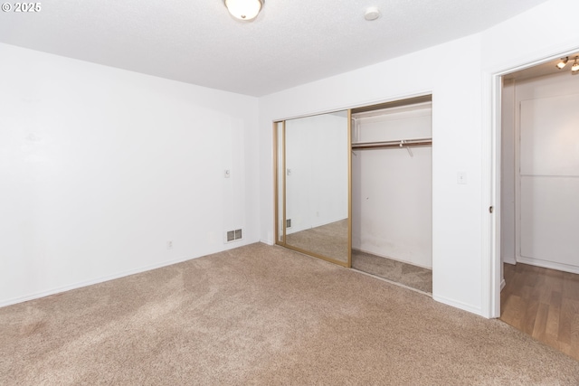 unfurnished bedroom featuring carpet and a closet