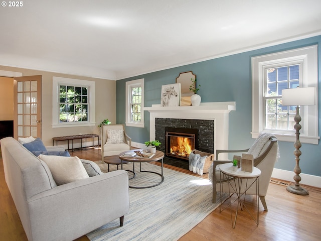 4214 NE Hassalo St, Portland, OR 97213 - living area featuring healthy amount of natural light, wood finished floors, and a glass covered fireplace
