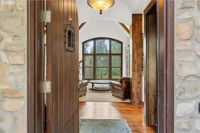 interior space with arched walkways and hardwood / wood-style floors