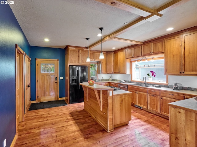 111 5th St, Silverton, OR 97381 - kitchen with black fridge with ice dispenser, a sink, stainless steel dishwasher, light wood finished floors, and a textured ceiling