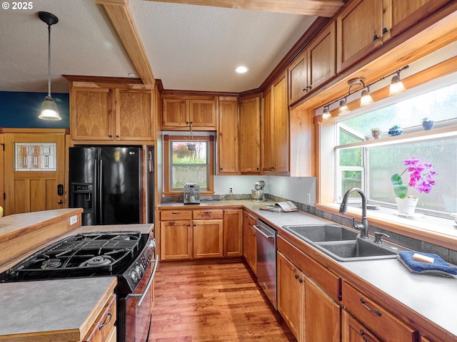 111 5th St, Silverton, OR 97381 - kitchen featuring black fridge, gas range oven, a sink, stainless steel dishwasher, and light wood finished floors