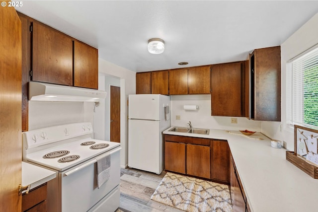 110 N Dean St, Coquille, OR 97423 - kitchen featuring white appliances, under cabinet range hood, a sink, light countertops, and brown cabinetry