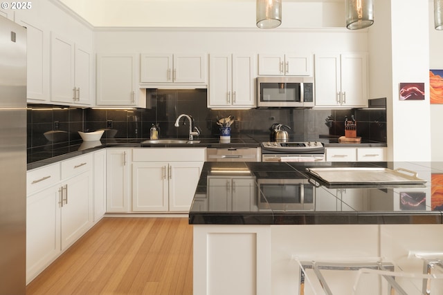 kitchen featuring sink, appliances with stainless steel finishes, and white cabinets