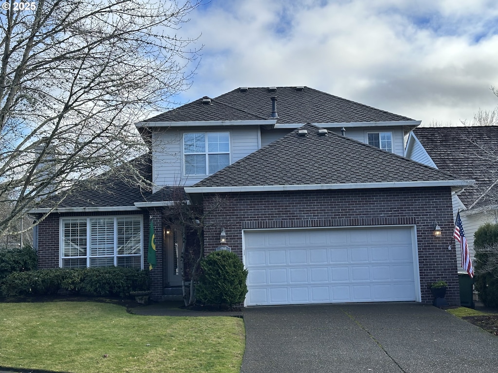 view of property featuring a garage and a front yard