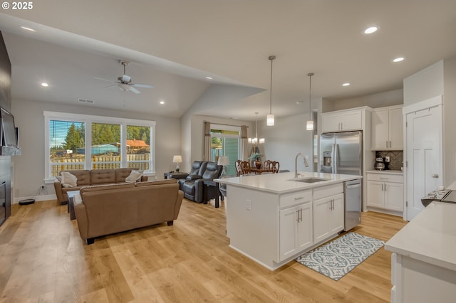 kitchen featuring appliances with stainless steel finishes, light wood-style floors, open floor plan, and a sink