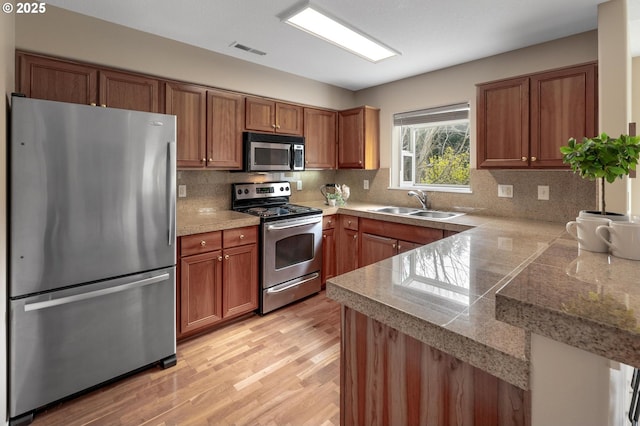 30326 SW Ruth St Unit 58, Wilsonville, OR 97070 - kitchen featuring visible vents, tile countertops, a sink, brown cabinetry, and appliances with stainless steel finishes