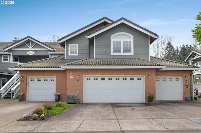 30326 SW Ruth St Unit 58, Wilsonville, OR 97070 - multi unit property featuring a tiled roof, central AC unit, driveway, a garage, and brick siding
