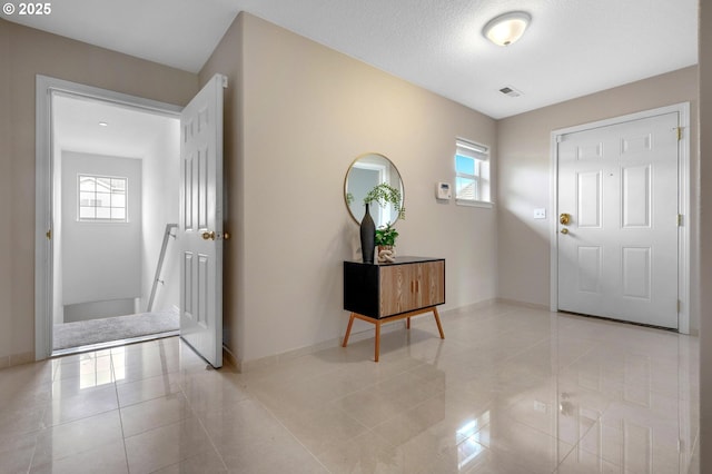 30326 SW Ruth St Unit 58, Wilsonville, OR 97070 - foyer featuring light tile patterned flooring, a healthy amount of sunlight, baseboards, and visible vents