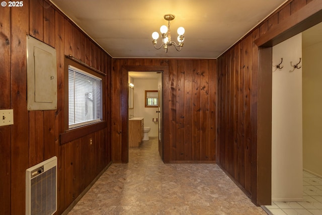 18570 Oakdale Rd, Dallas, OR 97338 - corridor featuring electric panel, wood walls, heating unit, a chandelier, and light floors