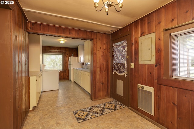 18570 Oakdale Rd, Dallas, OR 97338 - foyer entrance featuring light floors, a chandelier, wood walls, electric panel, and separate washer and dryer