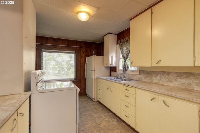 18570 Oakdale Rd, Dallas, OR 97338 - kitchen with a sink, light countertops, wooden walls, freestanding refrigerator, and cream cabinetry