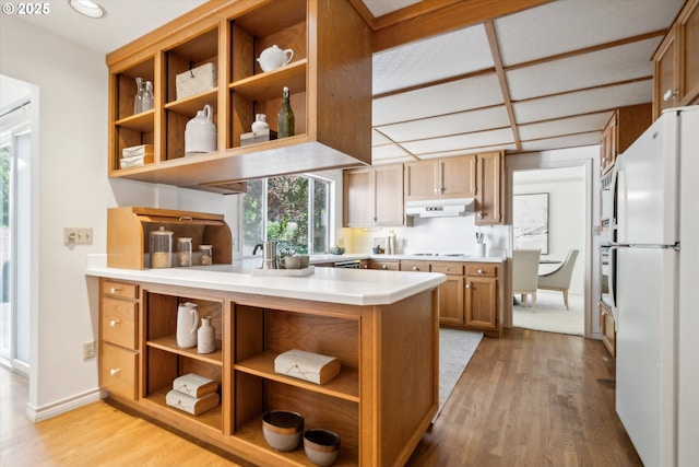 4401 SW Westdale Dr, Portland, OR 97221 - kitchen with freestanding refrigerator, open shelves, light wood-style flooring, light countertops, and baseboards