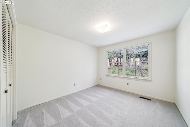 unfurnished bedroom with light carpet and a textured ceiling