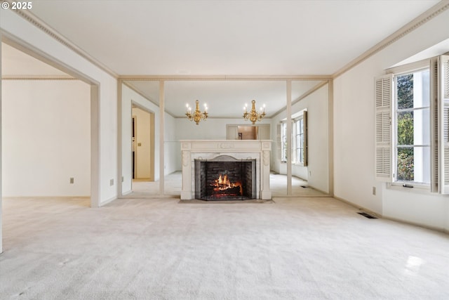 unfurnished living room featuring crown molding, a chandelier, a premium fireplace, and carpet