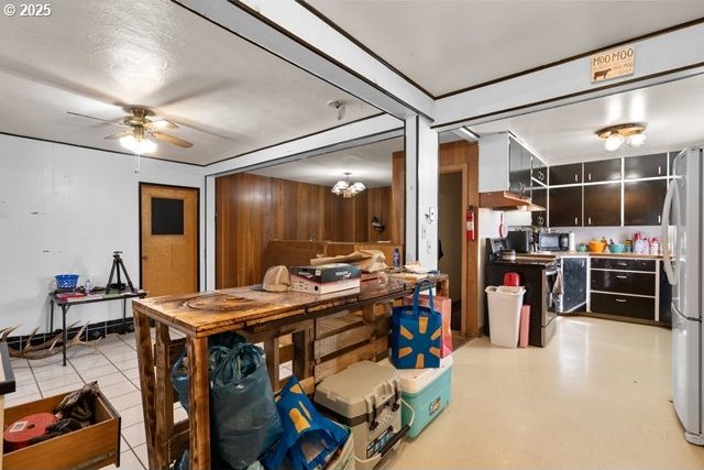 dining space with wooden walls and a ceiling fan