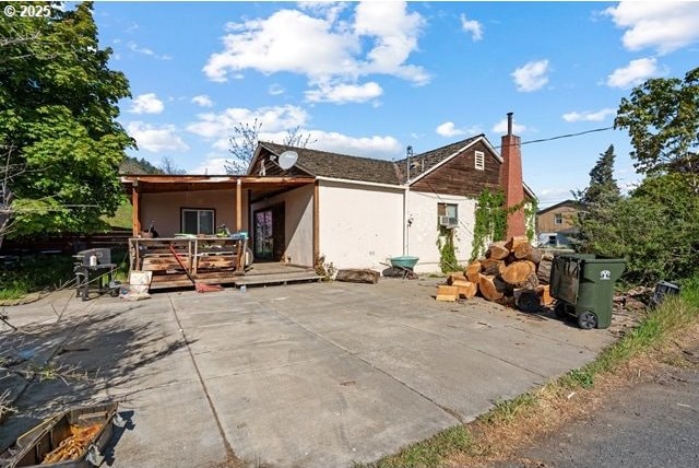 back of house with a patio, stucco siding, and a deck