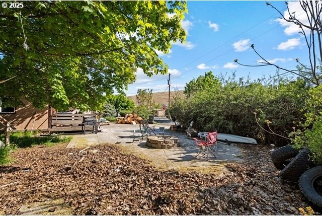 view of yard with an outdoor fire pit and a patio